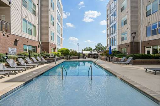 Outdoor pool with lounge chairs and seating at Link ® West End Apartments, South Carolina