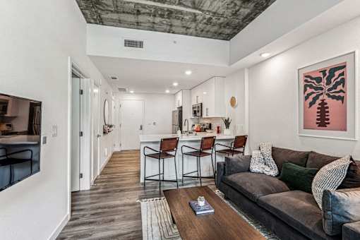 the living room is open to the kitchen and dining area at Link Apartments® Four 12, Oakland, 94607