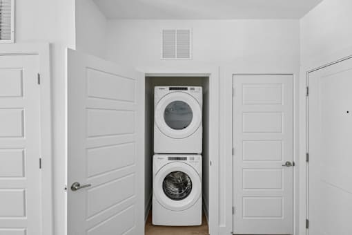 Stacked washer and dryer in closet at Link ® Lake Park Apartments, Smyrna