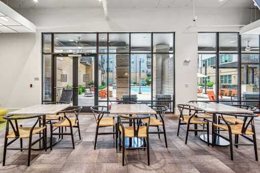 a dining area with tables and chairs and glass doors at Link Apartments Innovation Quarter, North Carolina, 27101