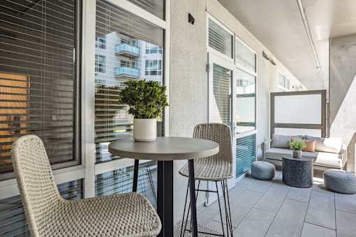a balcony with two chairs and a table with a potted plant at Link Apartments® Four 12, Oakland