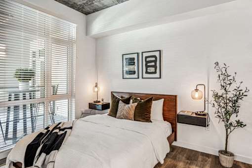 a bedroom with a bed and a large window at Link Apartments® Four 12, Oakland, CA