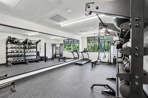 A well-equipped gym with various exercise machines and weights at Link Apartments® CYKEL Apartments, North Carolina, 28208