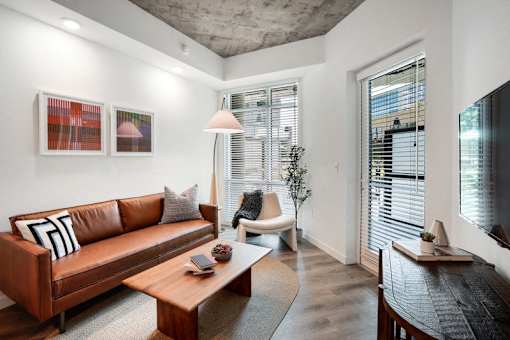 a living room with a leather couch and a coffee table at Link Apartments® Four 12, California, 94607
