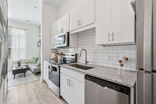 A modern kitchen with stainless steel appliances and white cabinets at Link Apartments® CYKEL Apartments, Charlotte, NC
