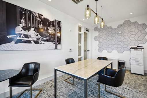 a conference room with a table and chairs and a poster on the wall at Link Apartments® 4th Street, North Carolina, 27101