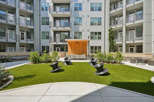 Courtyard with green lawn and modern sculptures at Link ® Lake Park Apartments, Smyrna, 30080