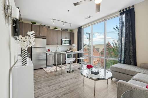 Open concept studio with kitchen and seating at Link ® West End Apartments, Greenville, SC 29601