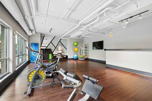 Fitness studio with exposed ceilings and wood floors at Link ® West End Apartments, Greenville, South Carolina