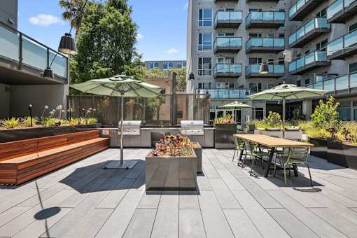 a rendering of a patio with tables and umbrellas at Link Apartments® Four 12, Oakland