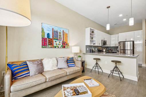 a living room with a couch and a kitchen at Link Apartments Innovation Quarter, Winston Salem, NC