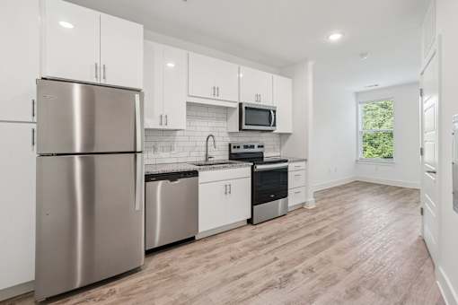 A modern kitchen with stainless steel appliances and white cabinets at Link Apartments® CYKEL Apartments, Charlotte, NC, 28208