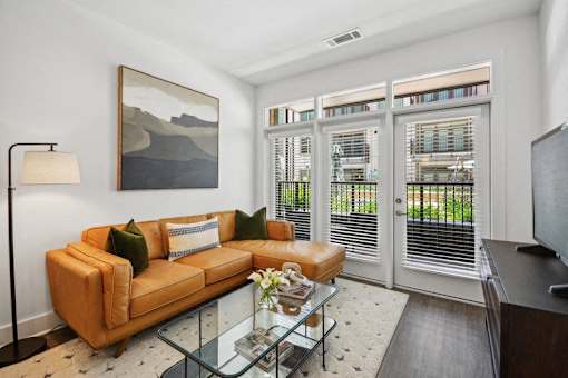 a living room with a couch and a glass coffee table at Link Apartments® 4th Street, Winston-Salem, NC