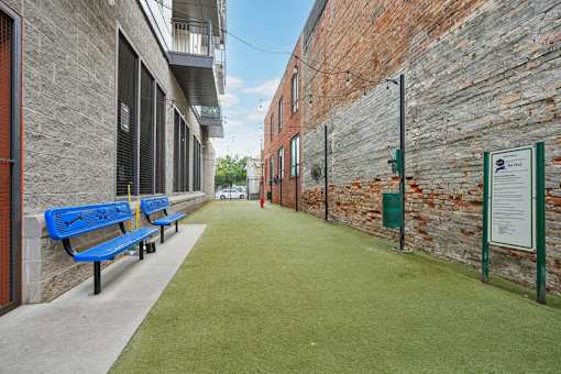 Outdoor walkway with artificial turf and benches at Link ® West End Apartments, Greenville, SC 29601