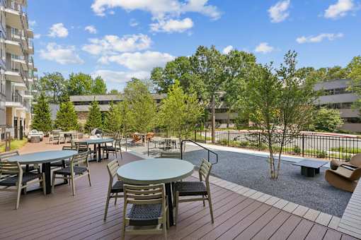 Outdoor patio with dining tables and playground at Link ® Lake Park Apartments, Georgia