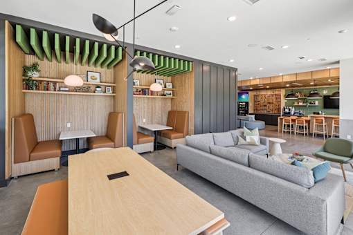 A modern living room with a grey sofa, wooden table at Link Apartments® CYKEL Apartments, North Carolina