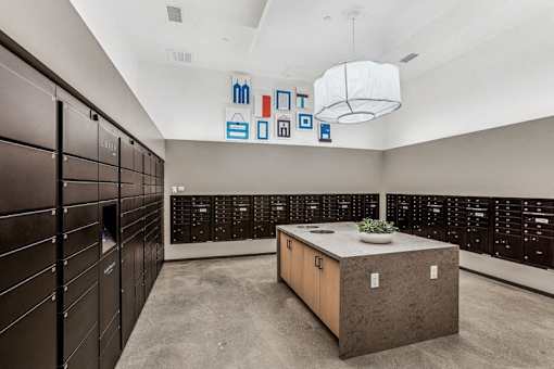 a large locker room with wooden cabinets and a table with a plant at Link Apartments® Four 12, California, 94607