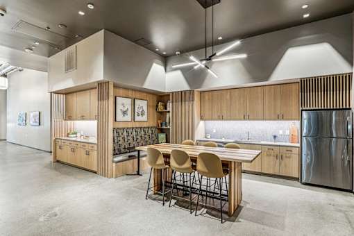a kitchen with a wooden table and chairs and a stainless steel refrigerator at Link Apartments® Four 12, Oakland, CA, 94607