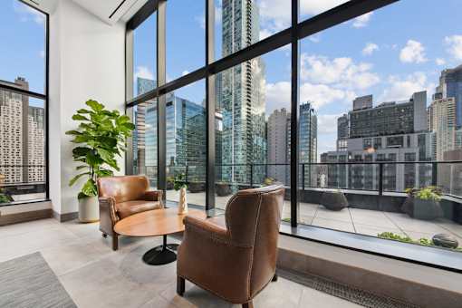 A room with a view of the cityscape through large windows at Link Apartments® QPN, Long Island City, New York