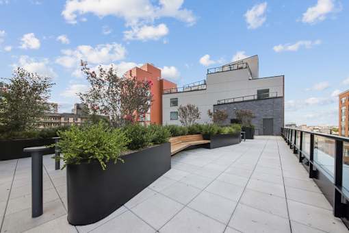 A modern building with a flat roof and a planter box at Link Apartments® QPN, Long Island City, New York