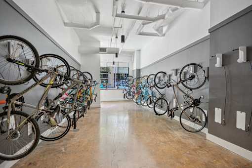 a row of bikes hanging on a wall in a room at Link Apartments® 4th Street, Winston-Salem, NC, 27101