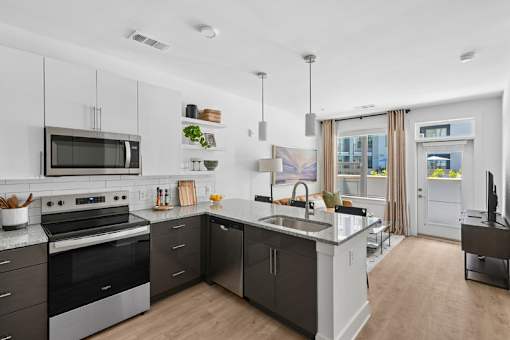 Contemporary kitchen with island and pendant lights at Link ® Lake Park Apartments, Smyrna, GA
