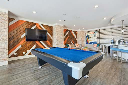Game room with pool table and lounge seating at Link ® West End Apartments, Greenville, South Carolina