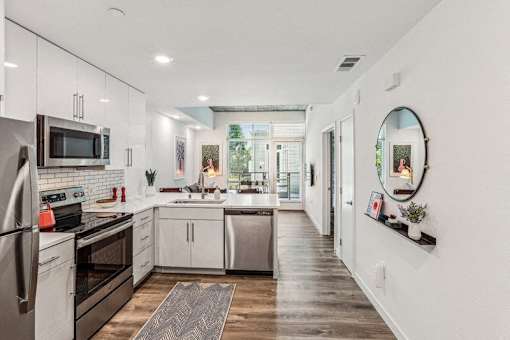 a large kitchen with white cabinets and stainless steel appliances at Link Apartments® Four 12, Oakland, CA