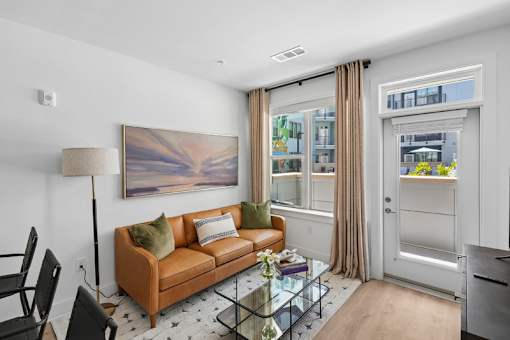 Living room with tan leather sofa and glass coffee table at Link ® Lake Park Apartments, Smyrna, 30080