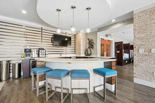 Clubhouse coffee bar with pendant lighting and seating at Link ® West End Apartments, Greenville