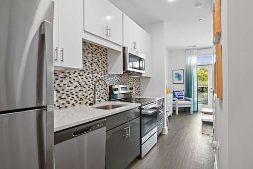 Studio kitchen with stainless steel appliances and quartz counters at Link Apartments® Mint Street in Uptown Charlotte, NC. at Link Apartments® Mint Street, Charlotte, NC, 28203