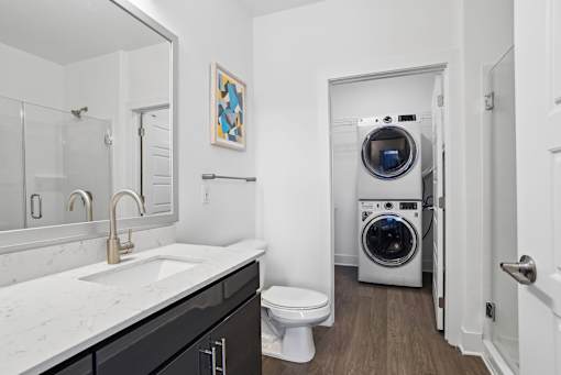 a bathroom with a toilet sink and a washing machine    and a laundry at Link Apartments® Mint Street, Charlotte, North Carolina