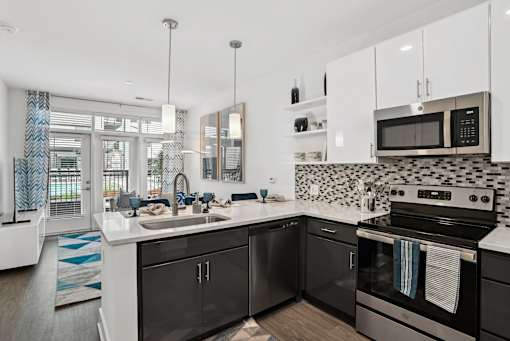 a kitchen with black and white appliances and a sink at Link Apartments® Mint Street, Charlotte, North Carolina