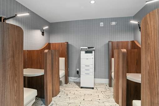 a bathroom with four stalls and a toilet and a sink at Link Apartments® Mint Street, Charlotte, North Carolina