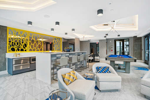 a clubhouse with a pool table and a bar at Link Apartments® Mint Street, North Carolina