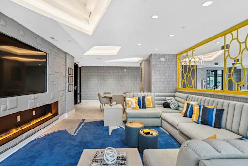 a living room with couches and a television and a fireplace at Link Apartments® Mint Street, Charlotte, NC
