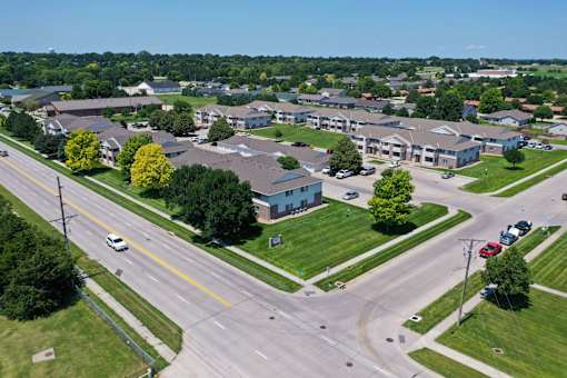 A road with cars and a building in the background.