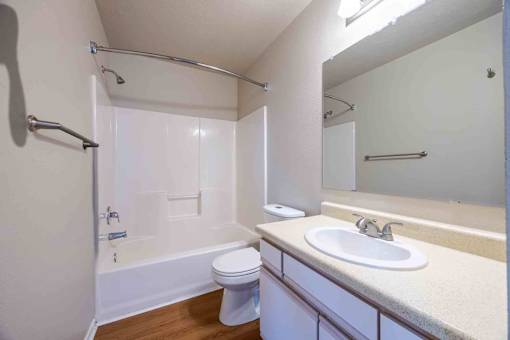 A white bathroom with a toilet, sink, and bathtub.