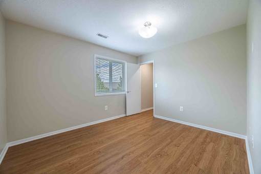 A room with wooden flooring and a window.