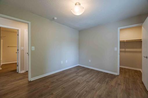 A room with wood flooring and white walls.