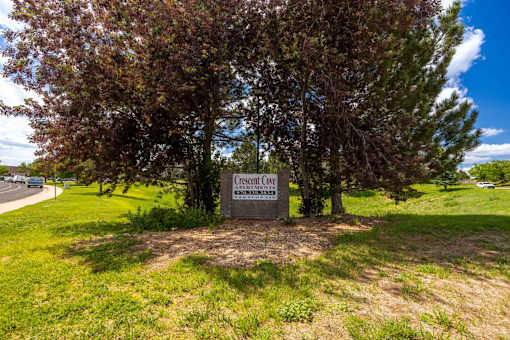 A sign in front of trees that says "Crescent Cove".