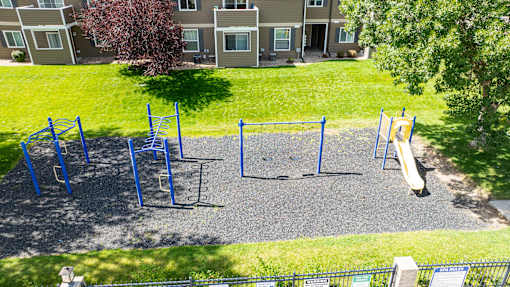 A playground with a slide, swings, and monkey bars.