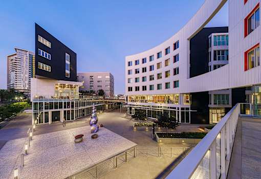A modern building with a black and white exterior and a courtyard with a fountain in the center.