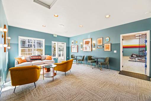 A living room with a yellow chair and a blue wall.