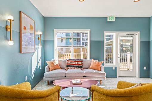 A living room with a grey couch and yellow chairs.