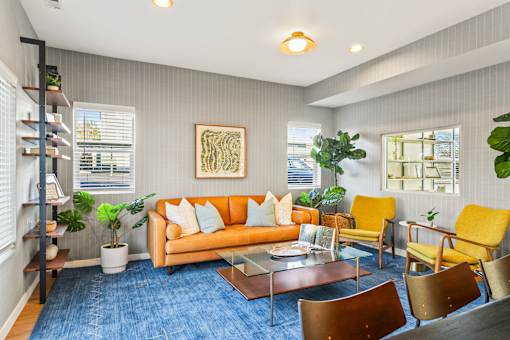 A living room with a blue carpet and a yellow chair.