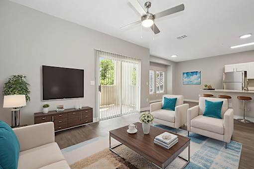 A living room with a white couch, a wooden coffee table, and a flat screen TV.