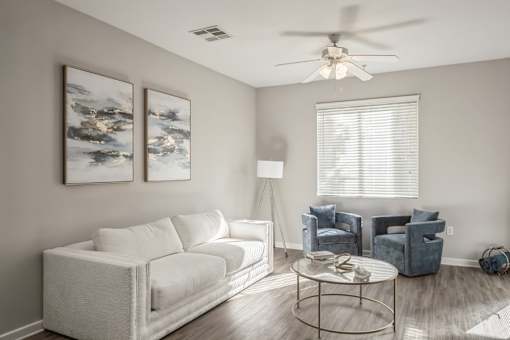 a living room with a white couch and a ceiling fan