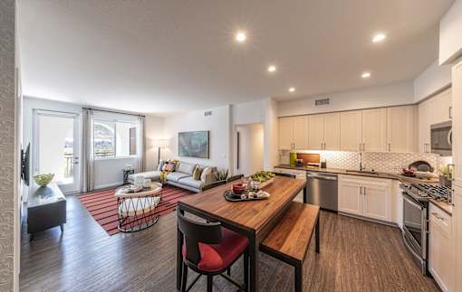 a kitchen and living room with a wooden table and chairs