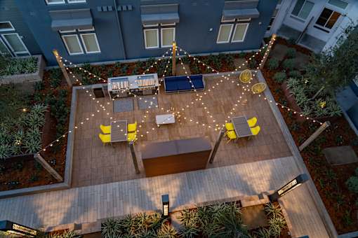 an aerial view of a patio with chairs and lights